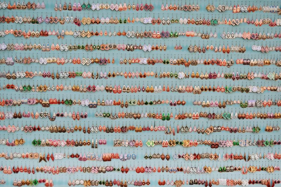 Rows of handmade earrings displayed for sale at a jewellery stall